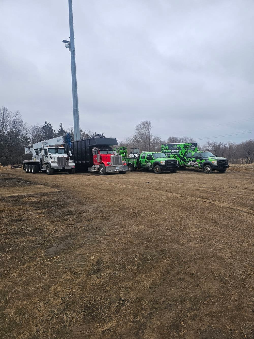 Trucks and rescue vehicles lined up at a construction site under a cloudy sky.